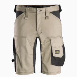 Beige cargo shorts with black side panels and multiple pockets, including a right thigh pocket with a yellow logo patch.